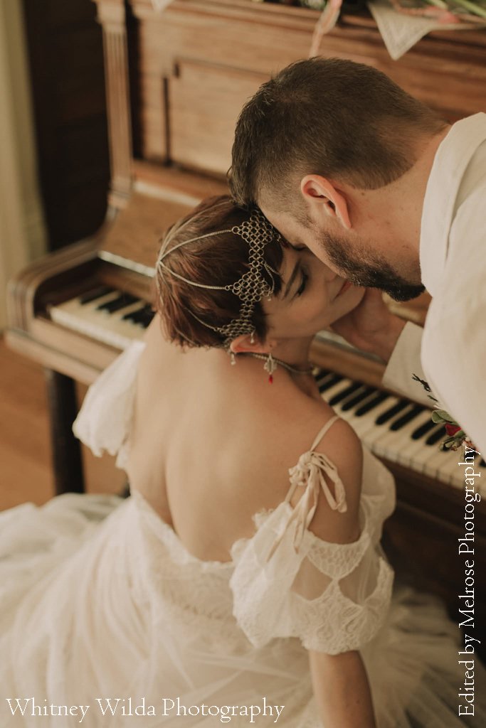 Bride and groom embracing beside the antique piano